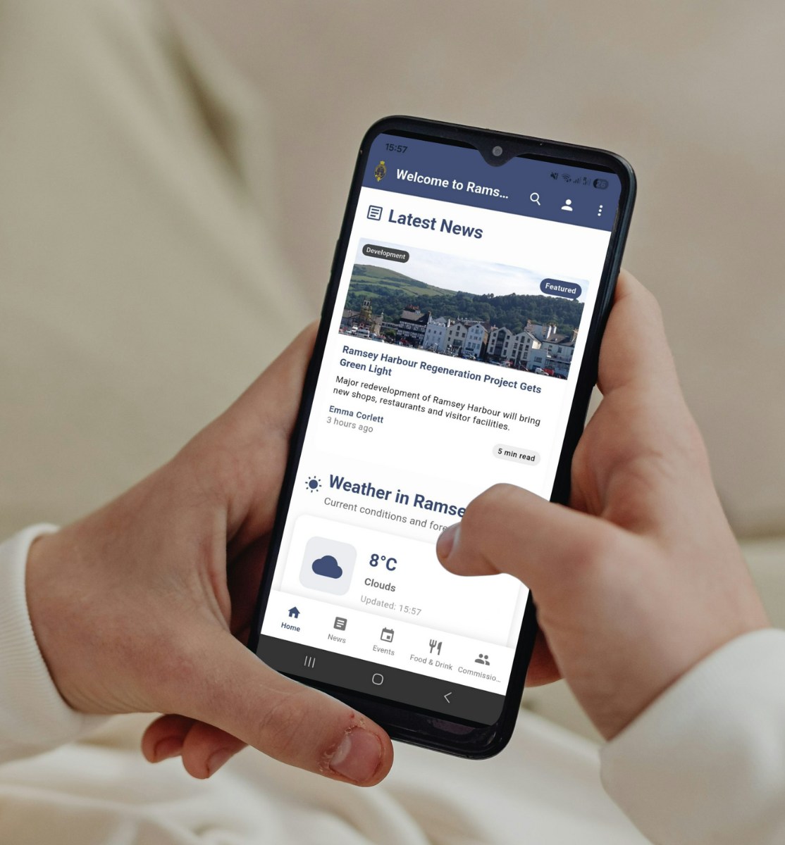 Hand holding smartphone displaying Ramsey Harbour news and weather app